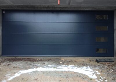 Une porte de garage sectionnelle à hublots à l’avantage de laisser la lumière naturel, installée par la société 3P HABITAT à Décines 69150Proximité de Lyon